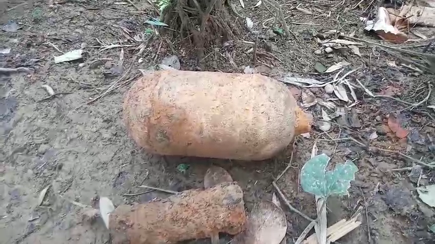 A rusted, cylindrical British-era bomb uncovered from a muddy excavation site in Shaliki Basti, Ledo, Assam, suspected to be from World War II.